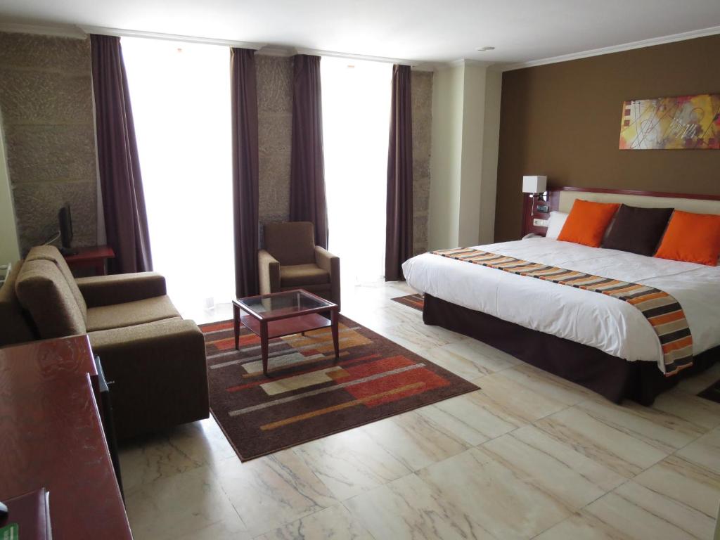 バイヨーナにあるHotel Anunciadaのベッドとソファ付きのホテルルーム