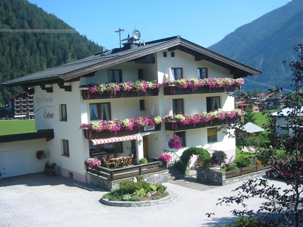 een groot wit gebouw met bloembakken erop bij Appart Lechner in Pertisau