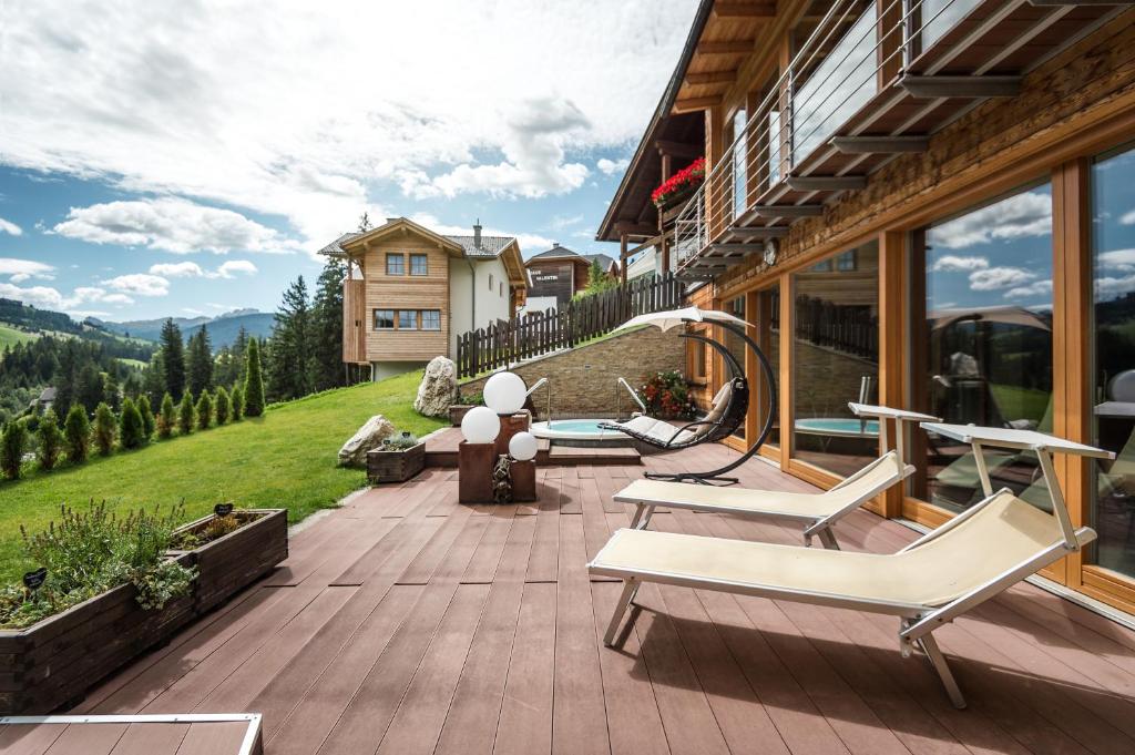 a patio with two lounge chairs and a house at Gourmet Hotel Gran Ander in Badia