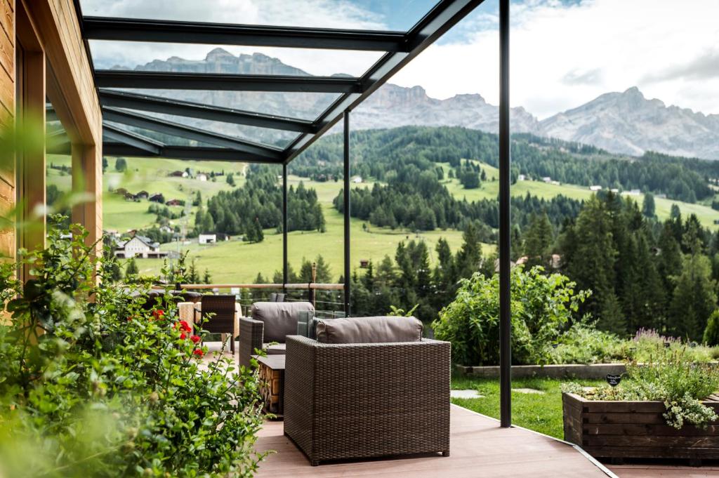 a patio with a view of the mountains through glass at Gourmet Hotel Gran Ander in Badia