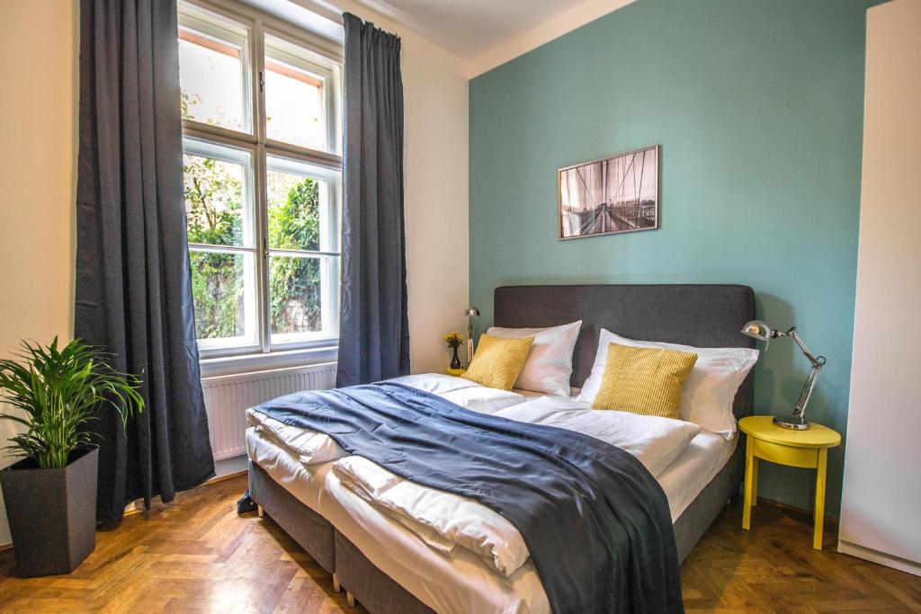 プラハにある3BDR City Center Ruterra Apartmentのベッドルーム1室(青い壁のベッド1台、窓付)