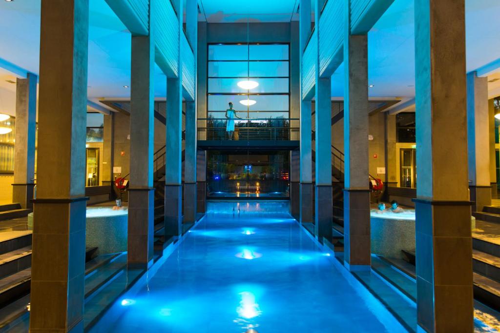 - une vue sur la piscine dans un bâtiment la nuit dans l'établissement Hotel & Wellness Zuiver, à Amsterdam