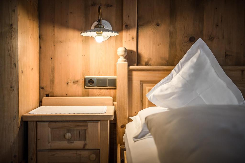 a bedroom with a bed and a wooden wall at Gourmet Hotel Gran Ander in Badia