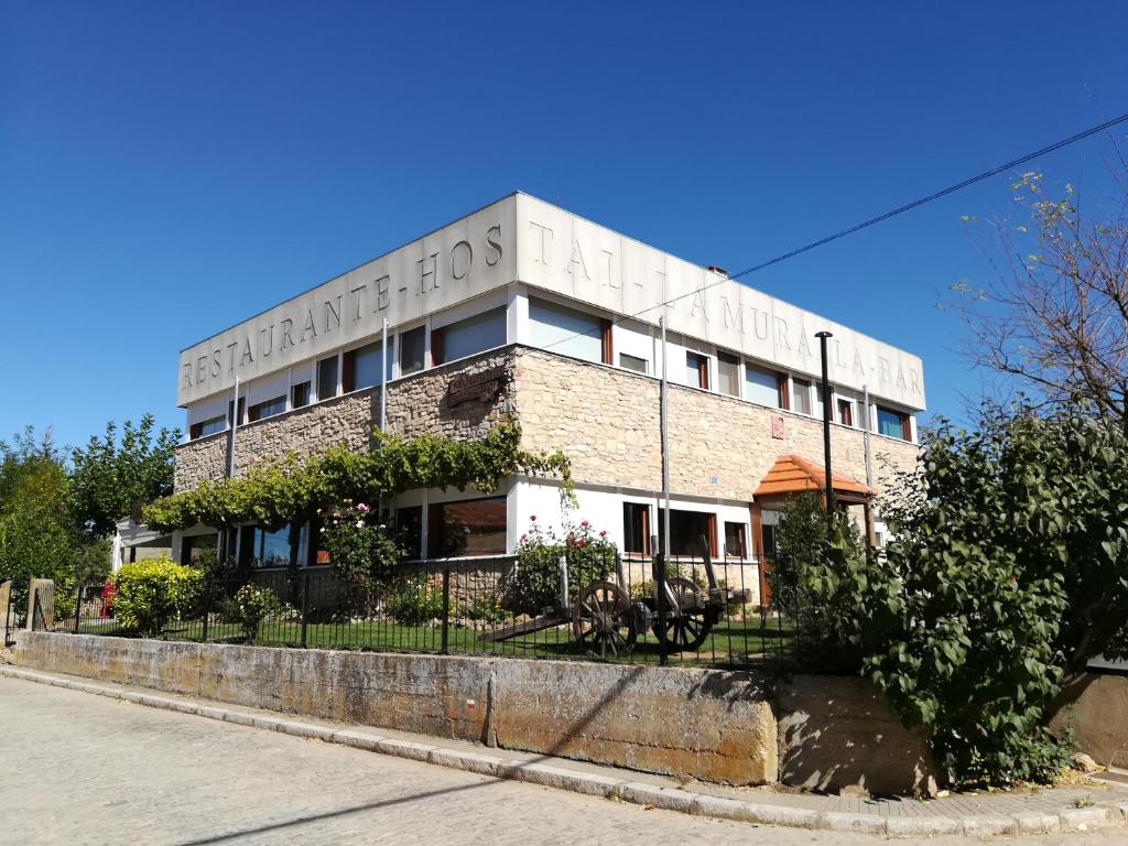 a brick building on the corner of a street at La Muralla in Retortillo de Soria