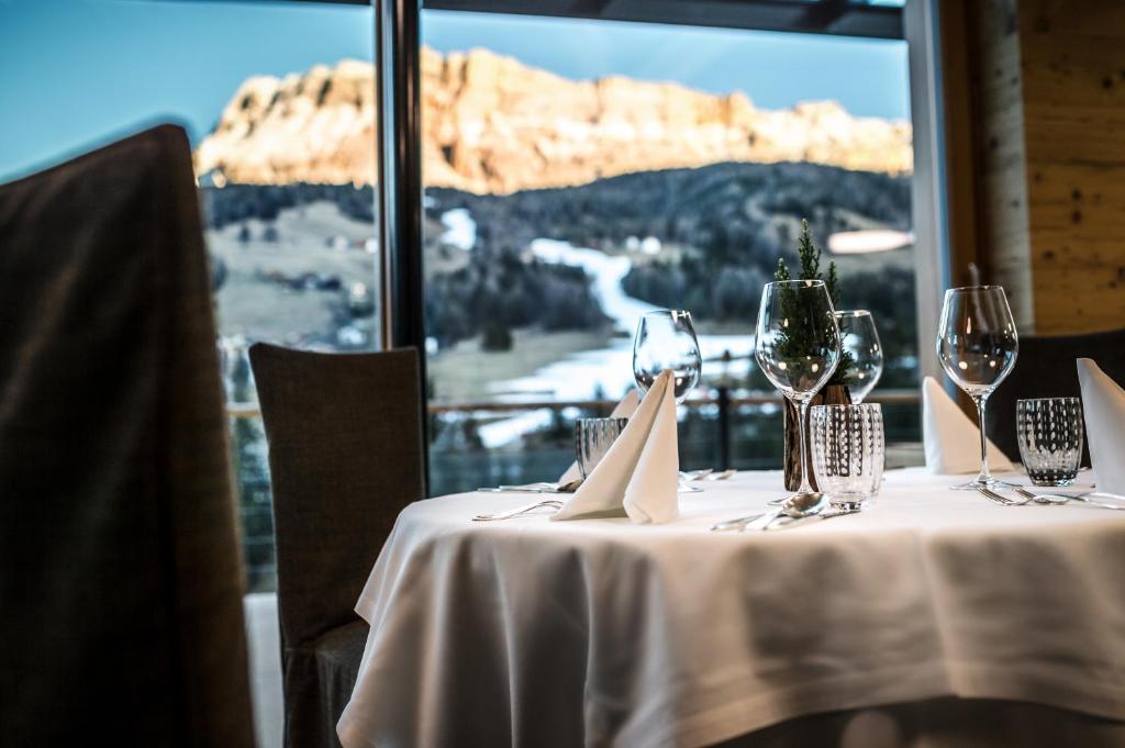 a table with wine glasses and a view of a mountain at Gourmet Hotel Gran Ander in Badia
