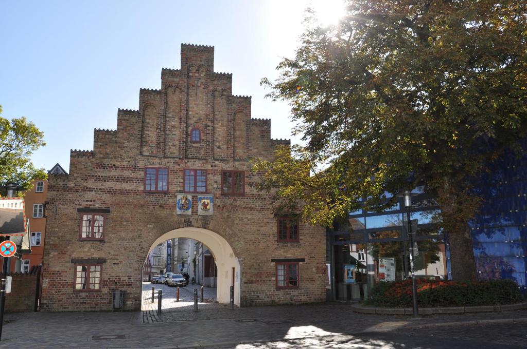 ein Backsteingebäude mit einem Torbogen in einer Stadt in der Unterkunft Ferienwohnung "Am Nordertor" in Flensburg