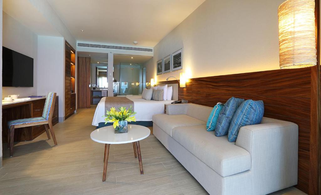 a hotel room with a couch and a bed at Emporio Cancun - Buy All Inclusive Option in Cancún
