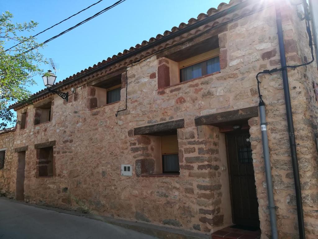 un viejo edificio de piedra con el sol brillando en él en Casa Rural La Muralla, en Retortillo de Soria