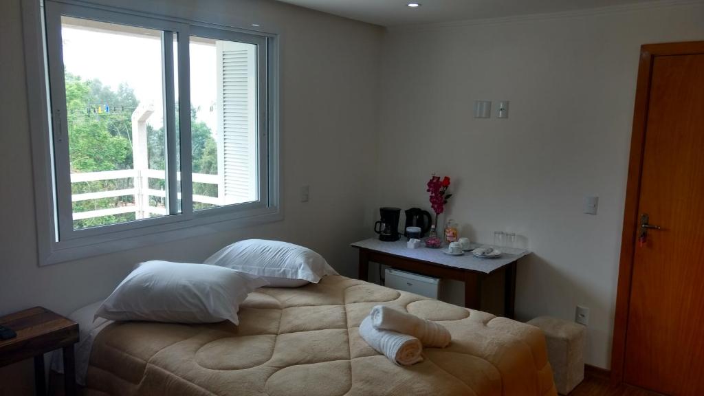 1 dormitorio con 1 cama con 2 toallas en Casa Zanata, en Gramado