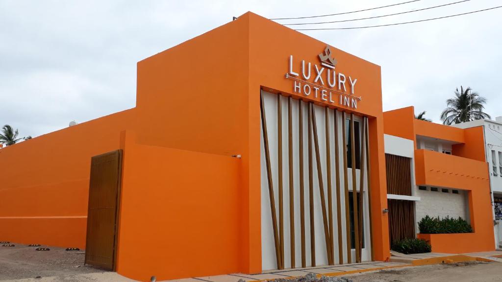 een oranje gebouw met een hotelbord erop bij Luxury Hotel Inn in La Peñita de Jaltemba