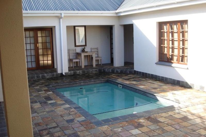 a swimming pool in the courtyard of a house at Baleia Guest Lodge in Hermanus