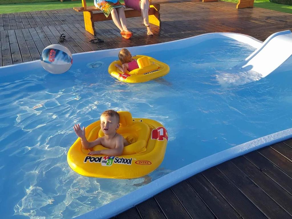 two young boys in a pool in a swimming pool at U Sasiadow in Mielenko