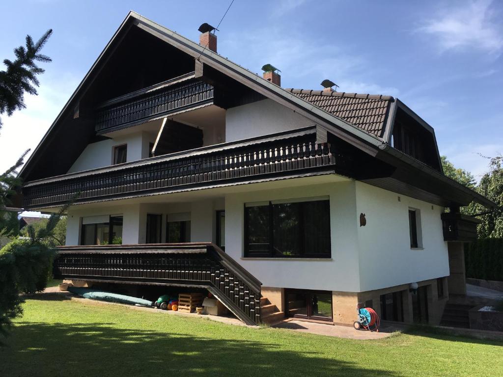 een wit huis met een zwart dak en een trap bij J-Max in Bled