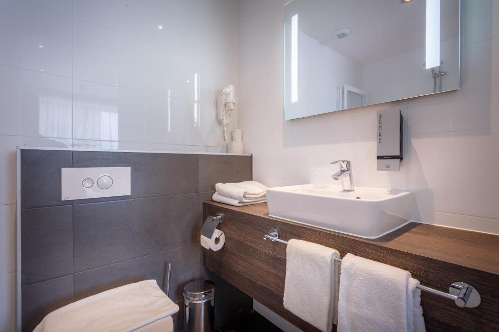 een badkamer met een witte wastafel en een toilet bij Joy Hotel in Amsterdam