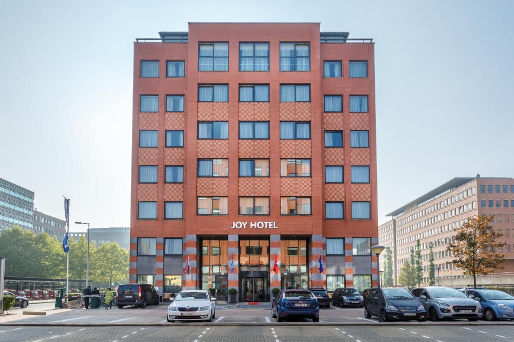 een hoog rood bakstenen gebouw met een hotelbord erop bij Joy Hotel in Amsterdam