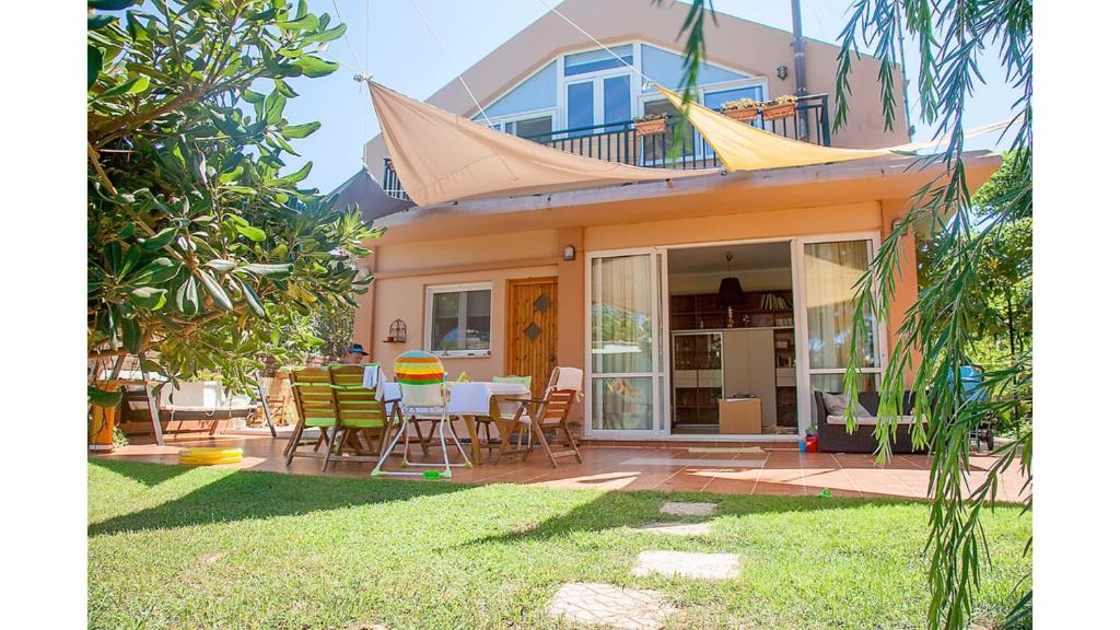 une maison avec une table et des chaises dans la cour dans l'établissement Villa Gerani, à Gerani