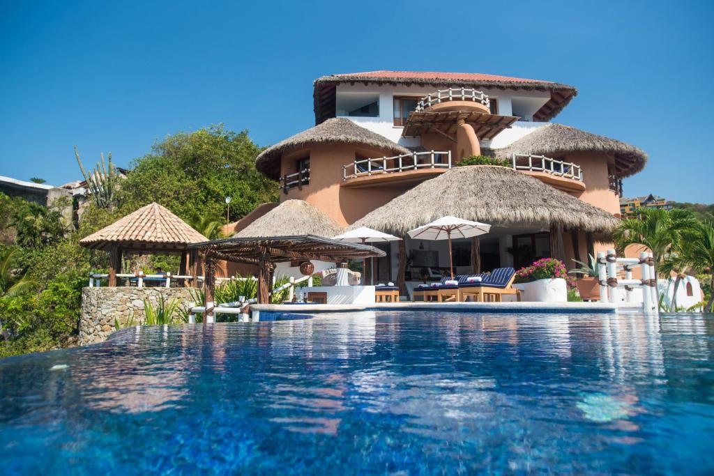 a resort with a swimming pool in front of a building at Villa El Murmullo by La Casa Que Canta in Zihuatanejo