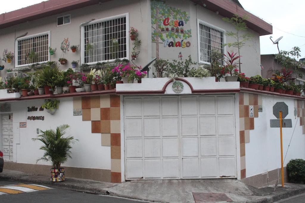 a building with a garage with potted plants on it at Casa Paraíso in Guayaquil