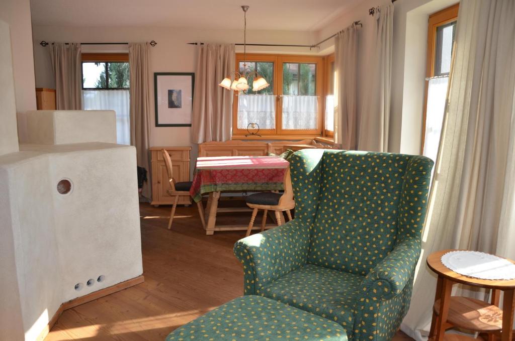 salon z zielonym krzesłem i stołem w obiekcie Haus Enzian w mieście Seefeld in Tirol