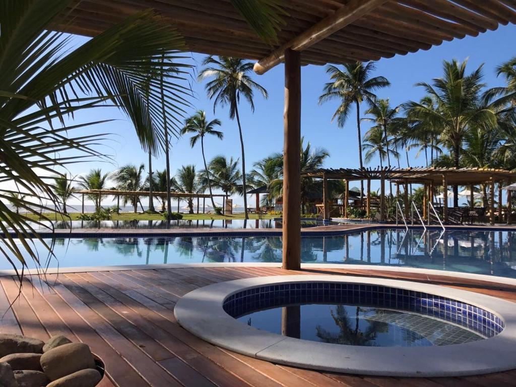 uma piscina num resort com palmeiras ao fundo em Resort Tororomba em Olivença