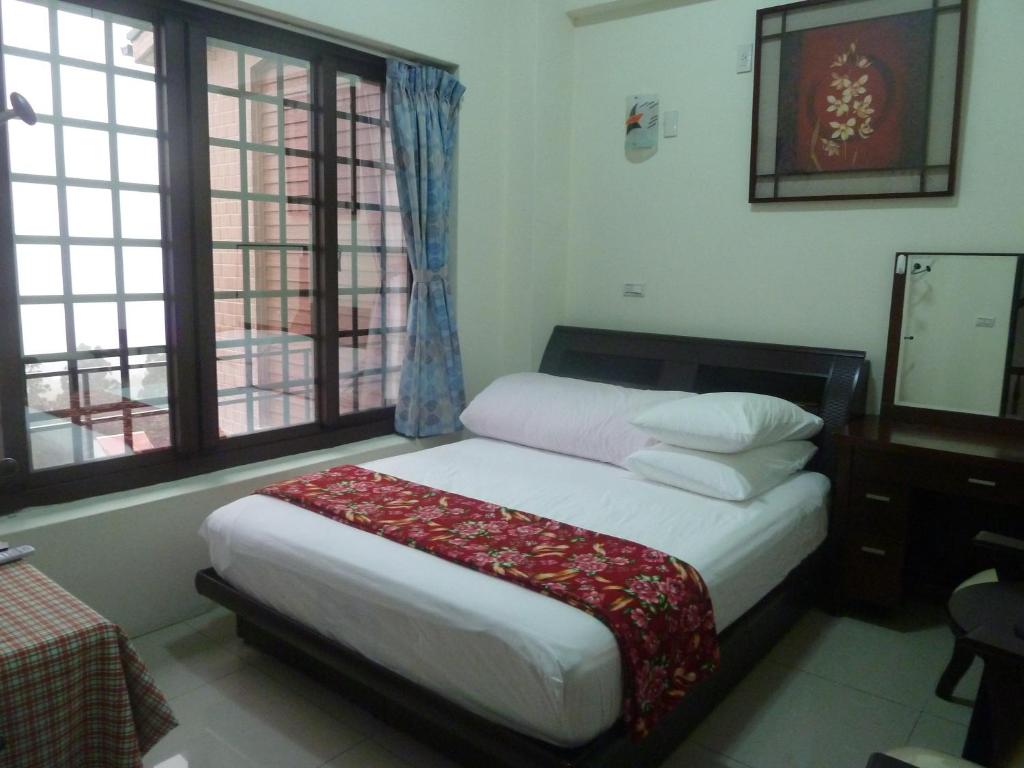 a bedroom with a bed in a room with windows at 奮起湖車站 揚揚民宿 in Fenchihu