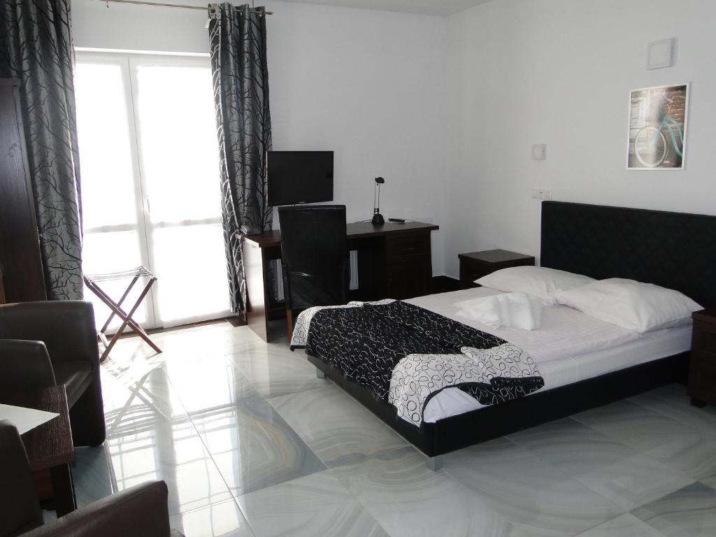 a bedroom with a bed and a desk and a window at Hotel Agat & SPA in Bydgoszcz