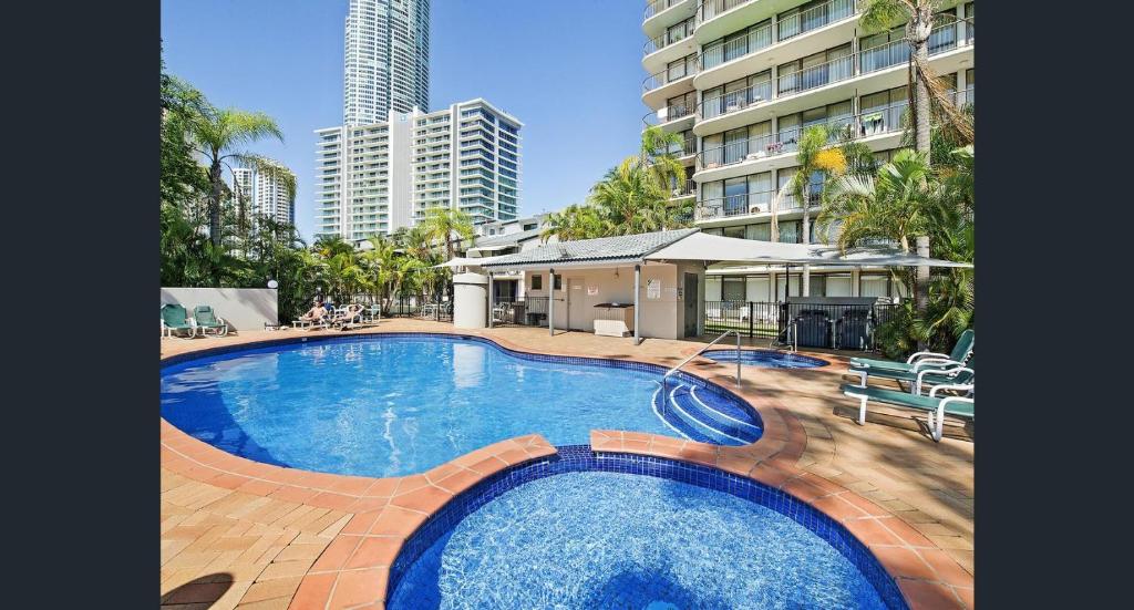 a swimming pool with a pool table and chairs at Anacapri Holiday Resort Apartments in Gold Coast