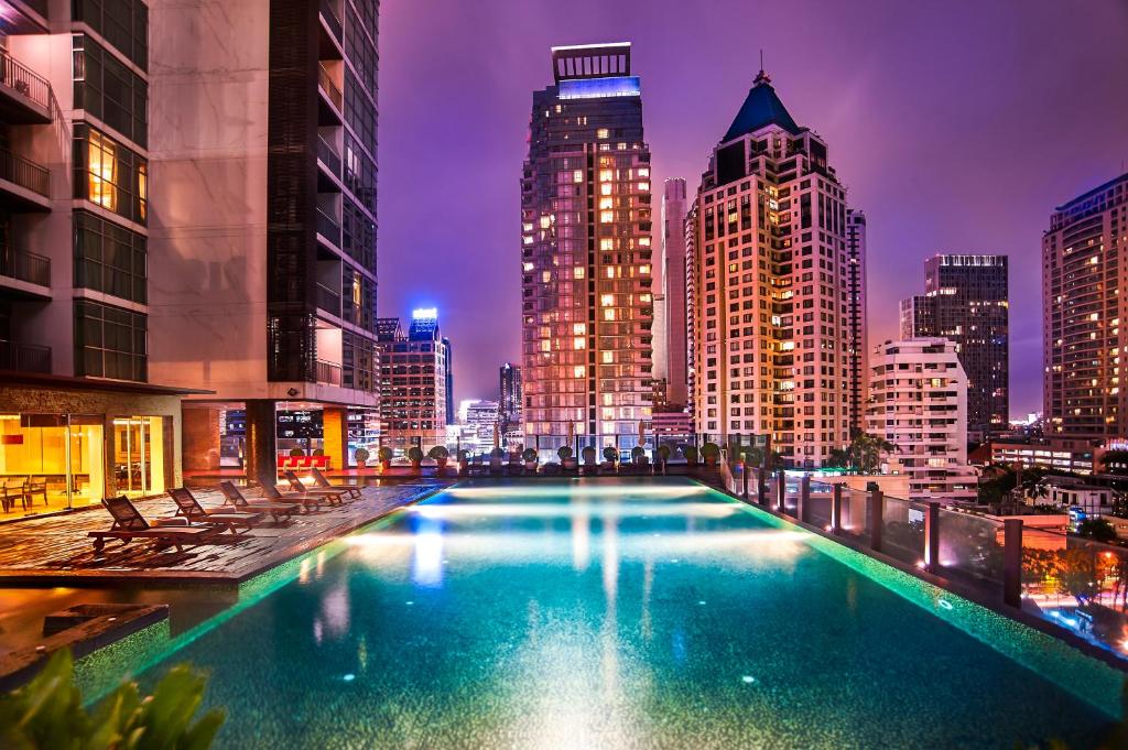 - une grande piscine avec vue sur la ville la nuit dans l'établissement Urbana Sathorn Hotel, Bangkok, à Bangkok