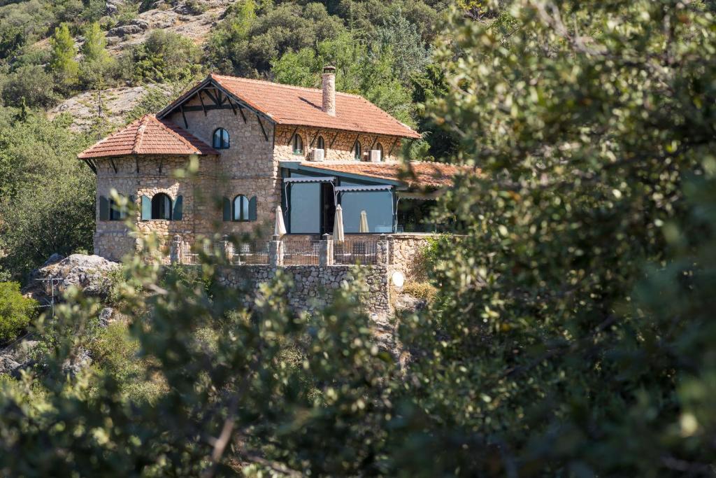 uma casa de pedra com um telhado vermelho numa colina em CALERILLA Hotel em Burunchel