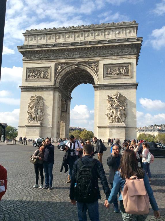 パリにあるエコ シャンゼリゼのエッフェル塔前に立つ人々