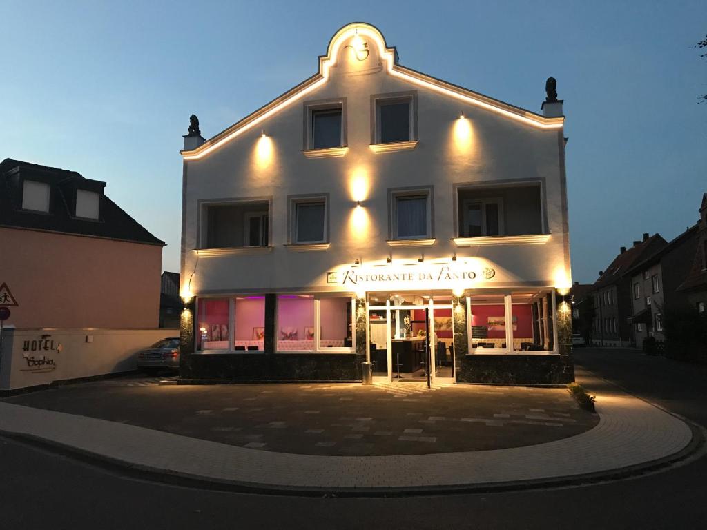 un gran edificio blanco con luces encendidas en Hotel Sophia, en Warendorf