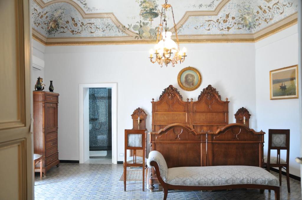 1 dormitorio con cama de madera y lámpara de araña en Casa Sipione Papa, en Módica