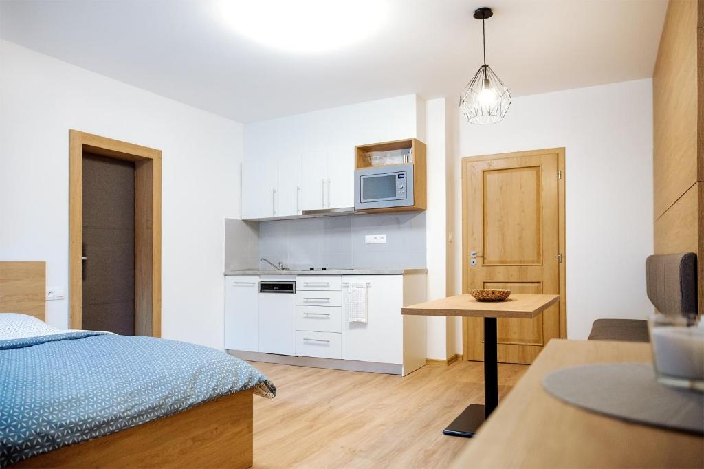 uma pequena cozinha com uma cama e um micro-ondas em Apartmány Na Čtvrtích em Dolní Bečva