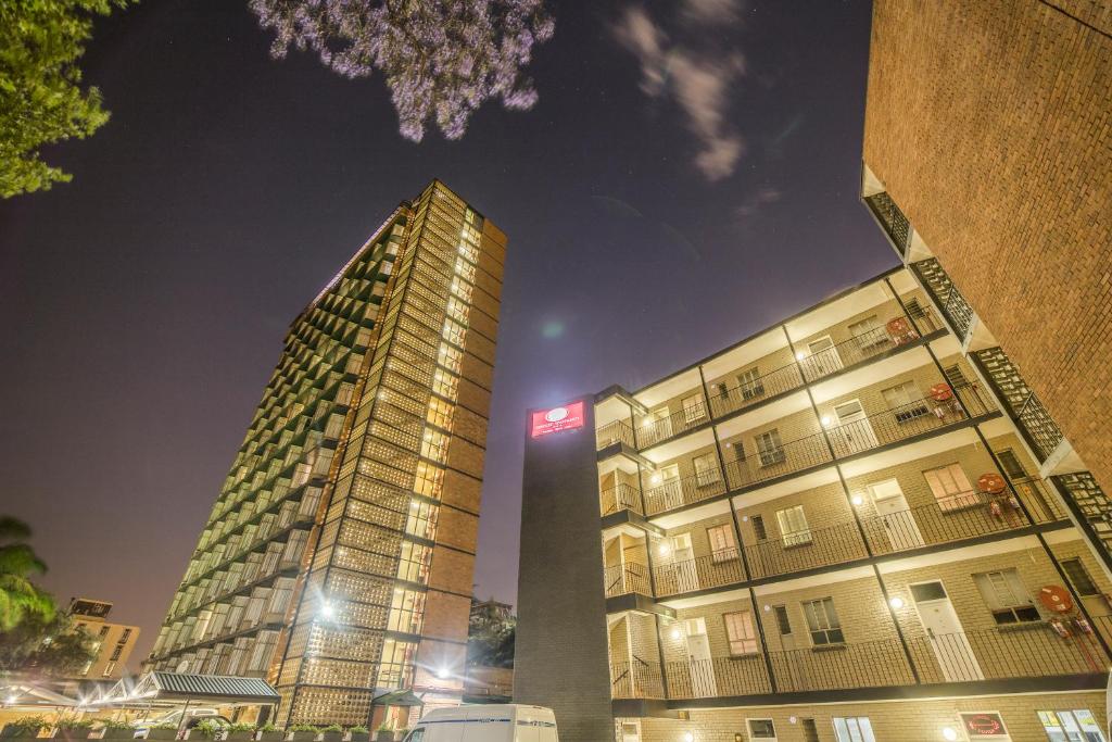 un grand bâtiment à côté d'un grand bâtiment la nuit dans l'établissement Hotel 224 & Apartments, à Pretoria