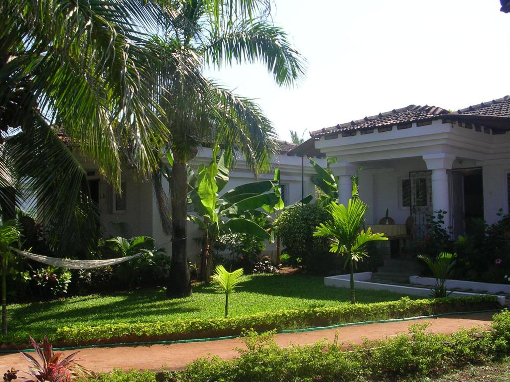 une maison blanche avec des palmiers et une cour dans l'établissement Villa Marigold, à Cavelossim