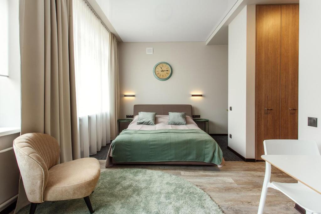 a bedroom with a bed and a chair and a table at Old Town Trio Apartments in Vilnius