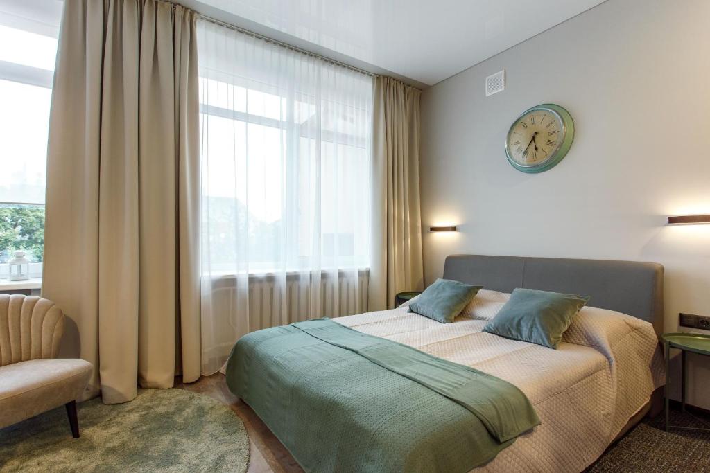 Old Town Trio Apartments — A bedroom with a bed and a clock on the wall