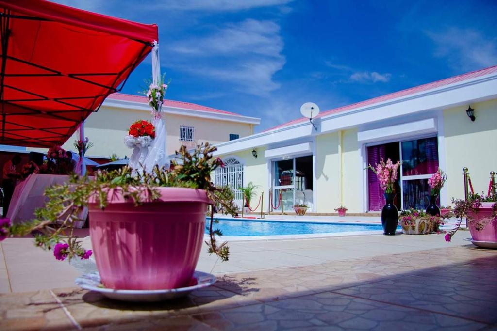 Casa con piscina y sombrilla roja en Petite Flower Guest House, en Talata-maty