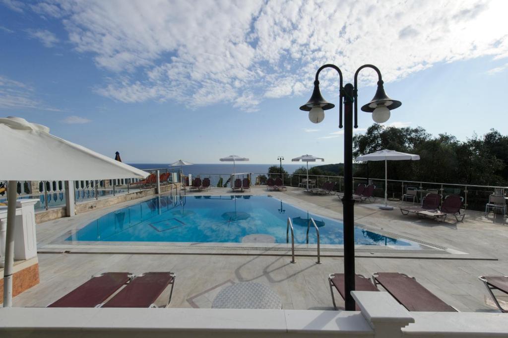 a large pool with chairs and a light pole at Kanali Studios in Parga