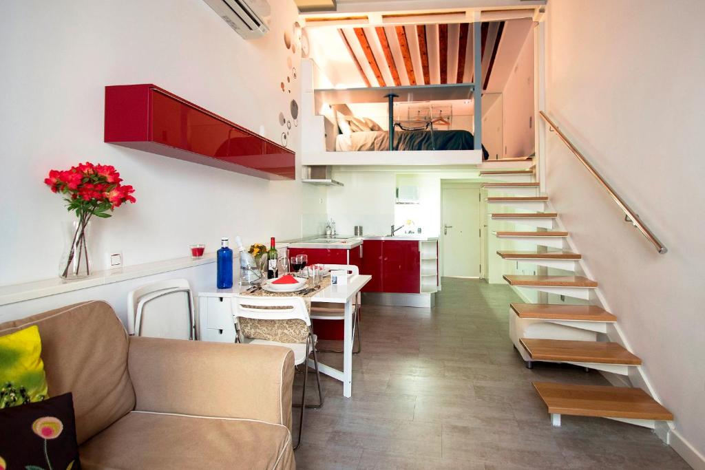 a living room with a staircase and a kitchen at Loft las letras in Madrid