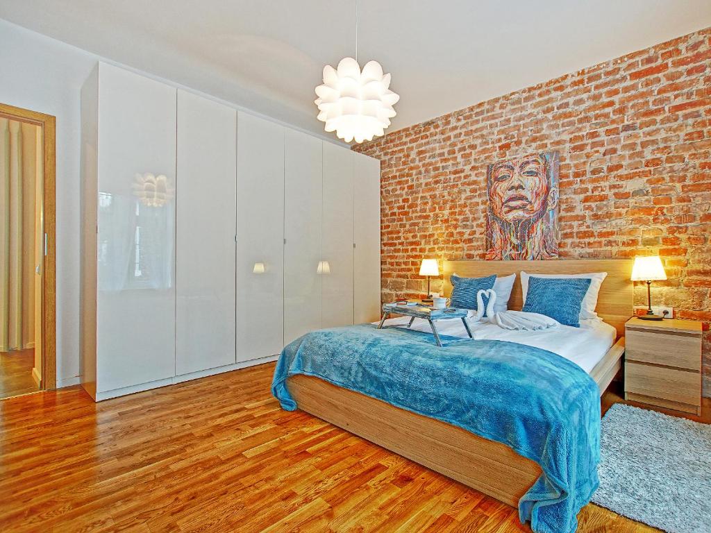 Un dormitorio con una pared de ladrillo y una cama en Apartament Starogdański przy ul Długiej, en Gdansk