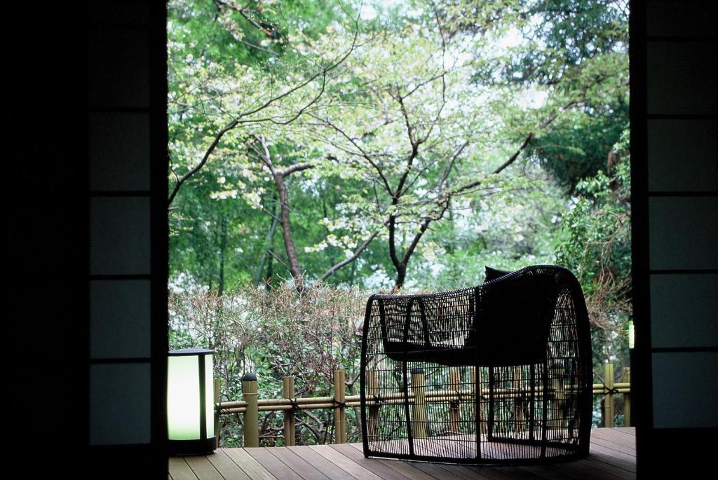 una silla sentada en un porche mirando por la ventana en Yoshidaya Sannoukaku, en Kaga