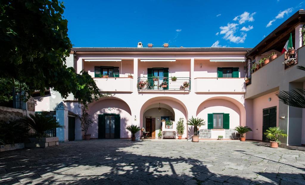 un grand bâtiment blanc avec une cour dans l'établissement La Masseria, à Capua