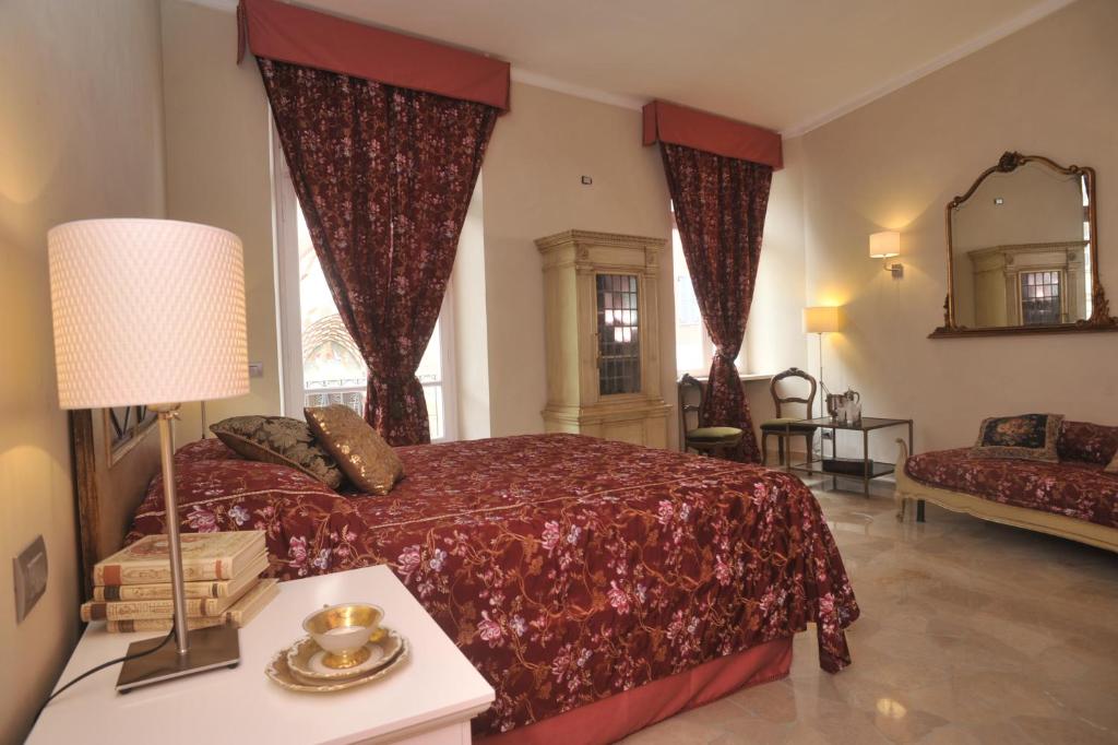 アルバにあるルレ アル ベル サン ドメーニコのベッドルーム(ベッド1台、ソファ、鏡付)