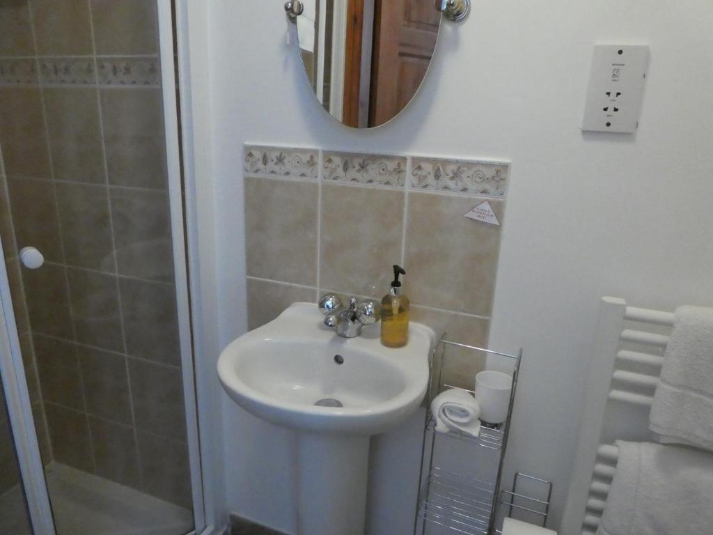 a bathroom with a sink and a shower with a mirror at West View Farm in Louth