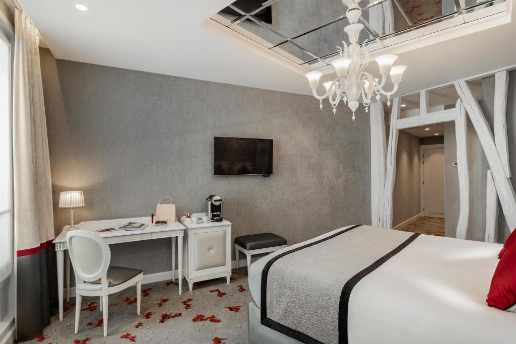 a room with a bed, a chair, and a tv at Maison Albar Hotels Le Diamond in Paris