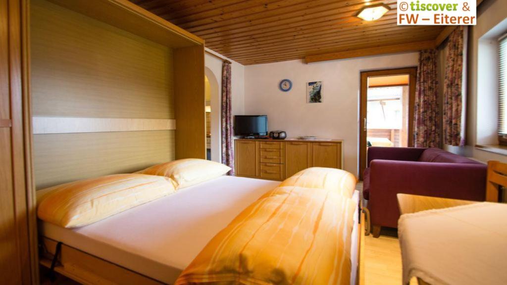 - une chambre avec deux lits et un canapé dans l'établissement Ferienwohnungen Eiterer, à Prutz