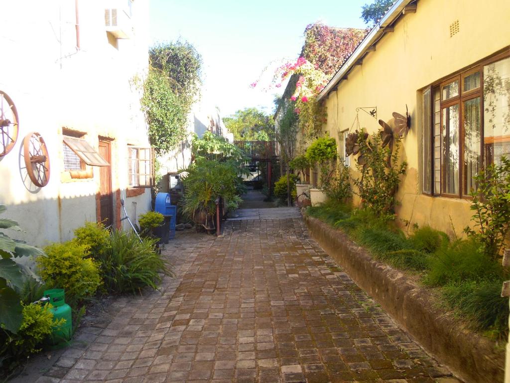 an alley between two buildings with plants on the sides at Hazyview Country Cottages in Hazyview