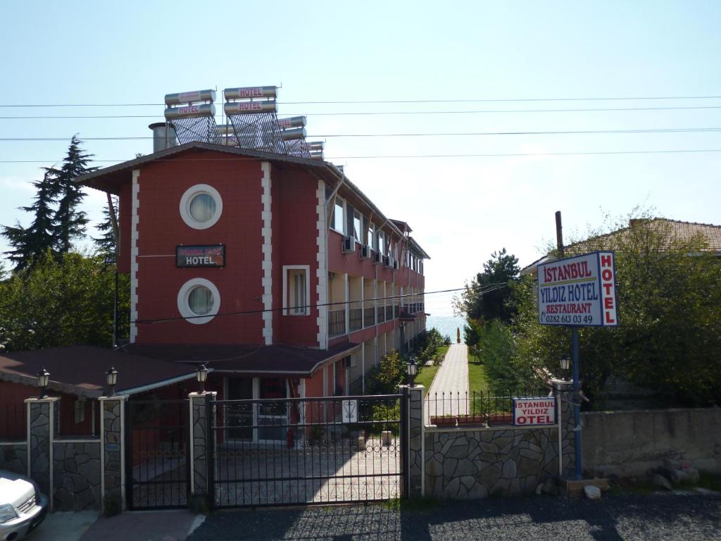 ein rotes Gebäude mit einem Schild davor in der Unterkunft Istanbul Yildiz Hotel in Marmaraereglisi