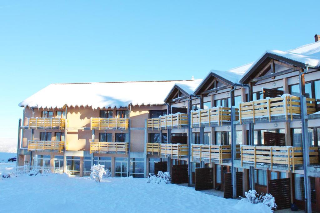 un grand bâtiment dans la neige dans l'établissement VVF Jura Les Rousses, à Prémanon